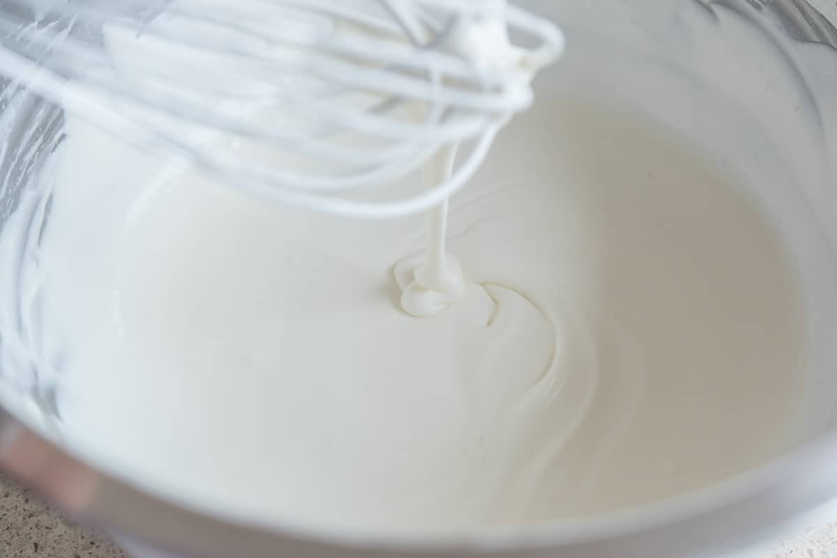 Slightly thickened cream dripping down from a balloon whisk