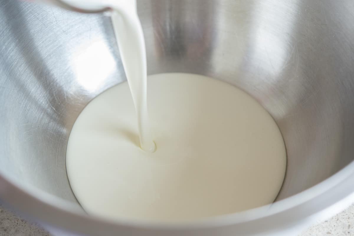 Pouring heavy cream into a mixing bowl
