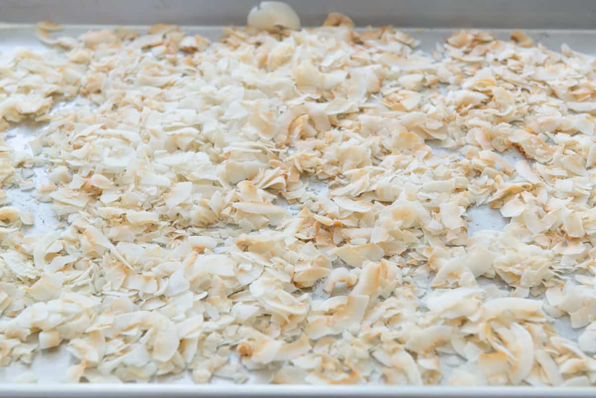 Golden brown toasted coconut flakes on a baking sheet