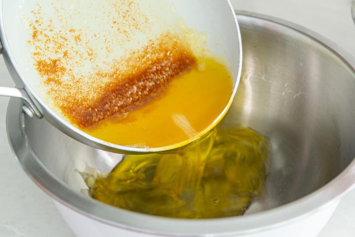Brown butter pouring into a heatproof bowl to cool