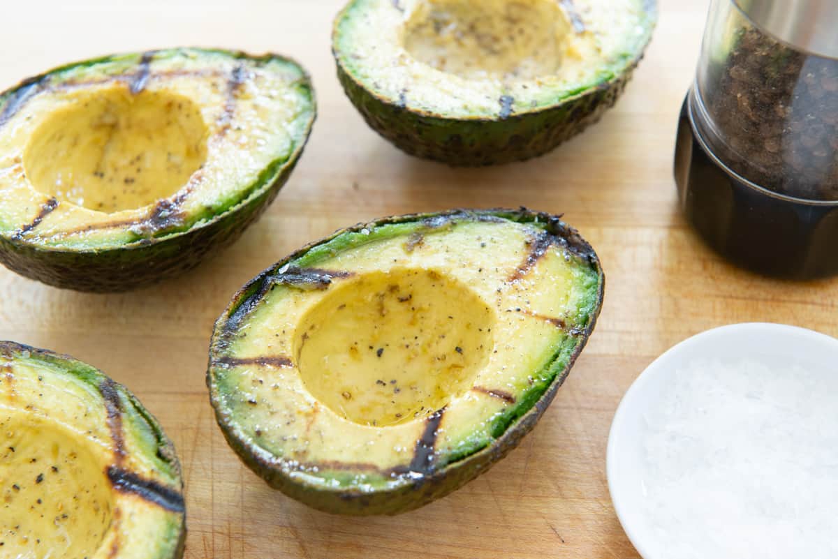 Grilled Avocado Halves On Cutting Board with Salt and Pepper