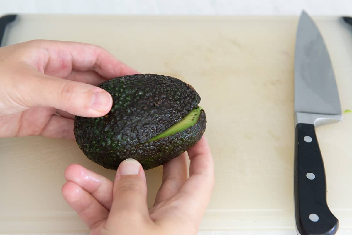 Using Hands To Twist Open A Cut Avocado