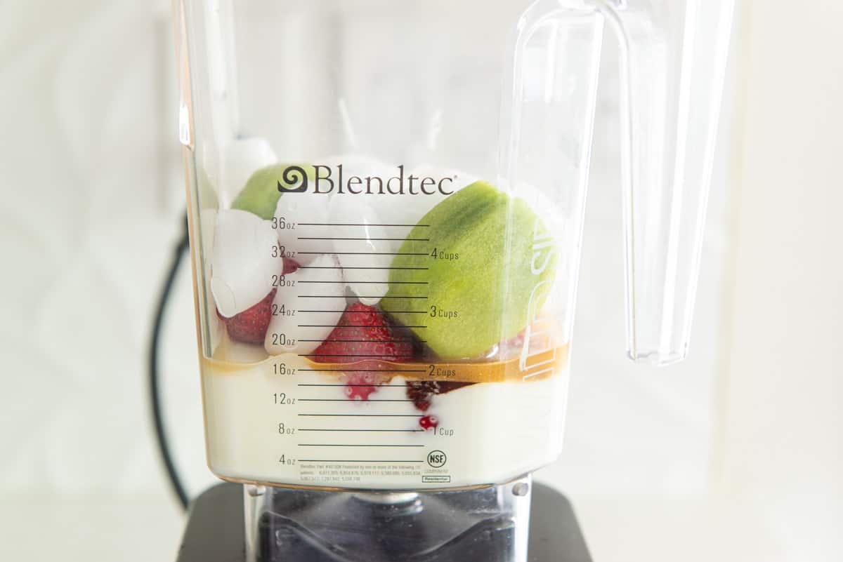 Fresh Kiwis, Strawberries, Ice, Yogurt, Honey in a Food Blender Jar