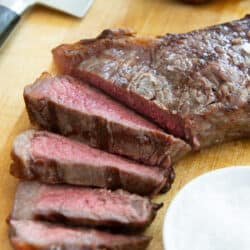 Tender Grilled NY Strip Steak Slices On Wooden Cutting Board