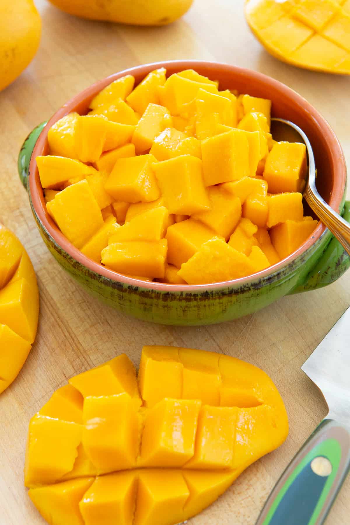 Mango Cubes In a bowl with Cut Mango Half On Board