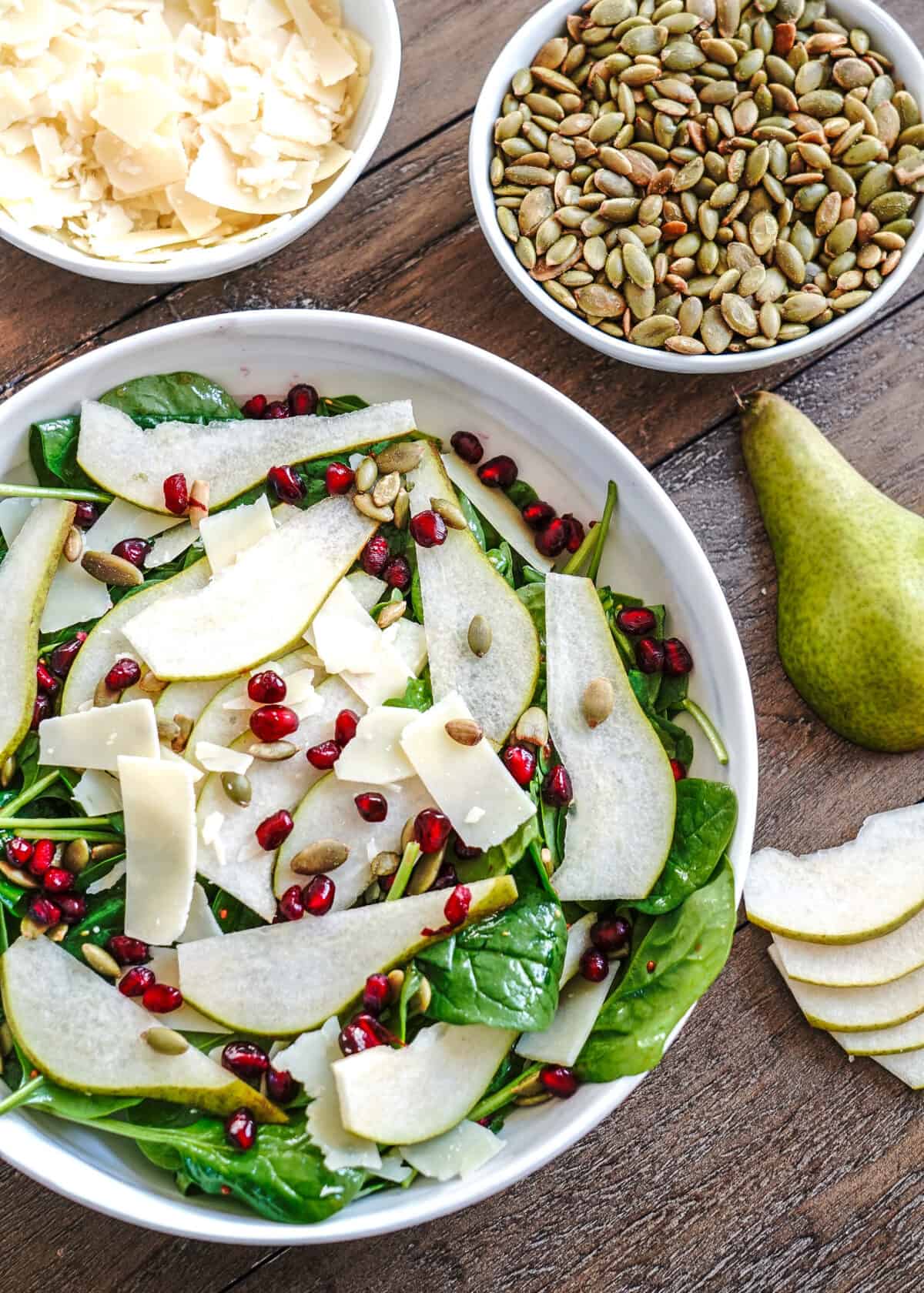 Pear Salad topped with Pepita seeds, pomegranate seeds, and shaved parmesean