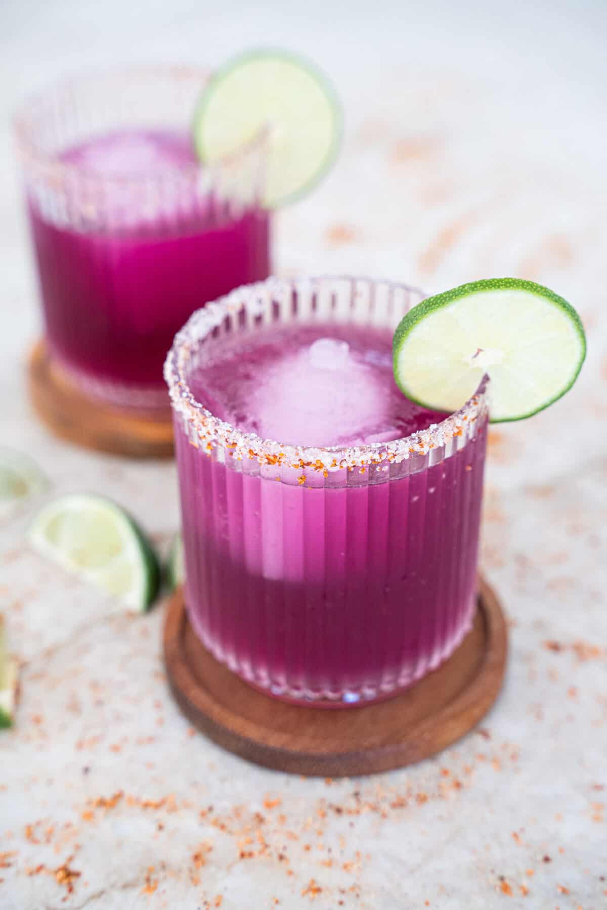 2 prickly pear margaritas with lime garnish