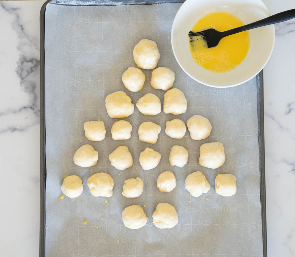 brushing egg wash on bread balls