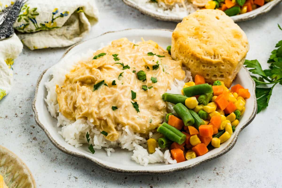 plated chicken and gravy with veggies and biscuit