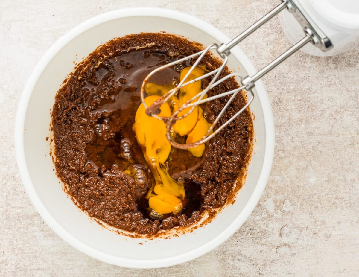 mixing egg and vanilla into brownie mixture